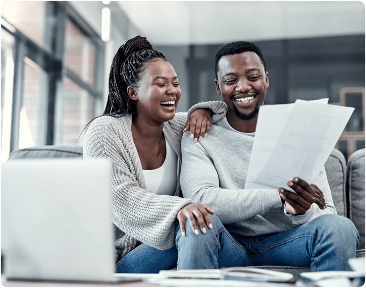 Couple smiling and looking at documents.