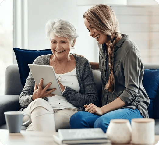 Woman helping older woman with her tablet. 