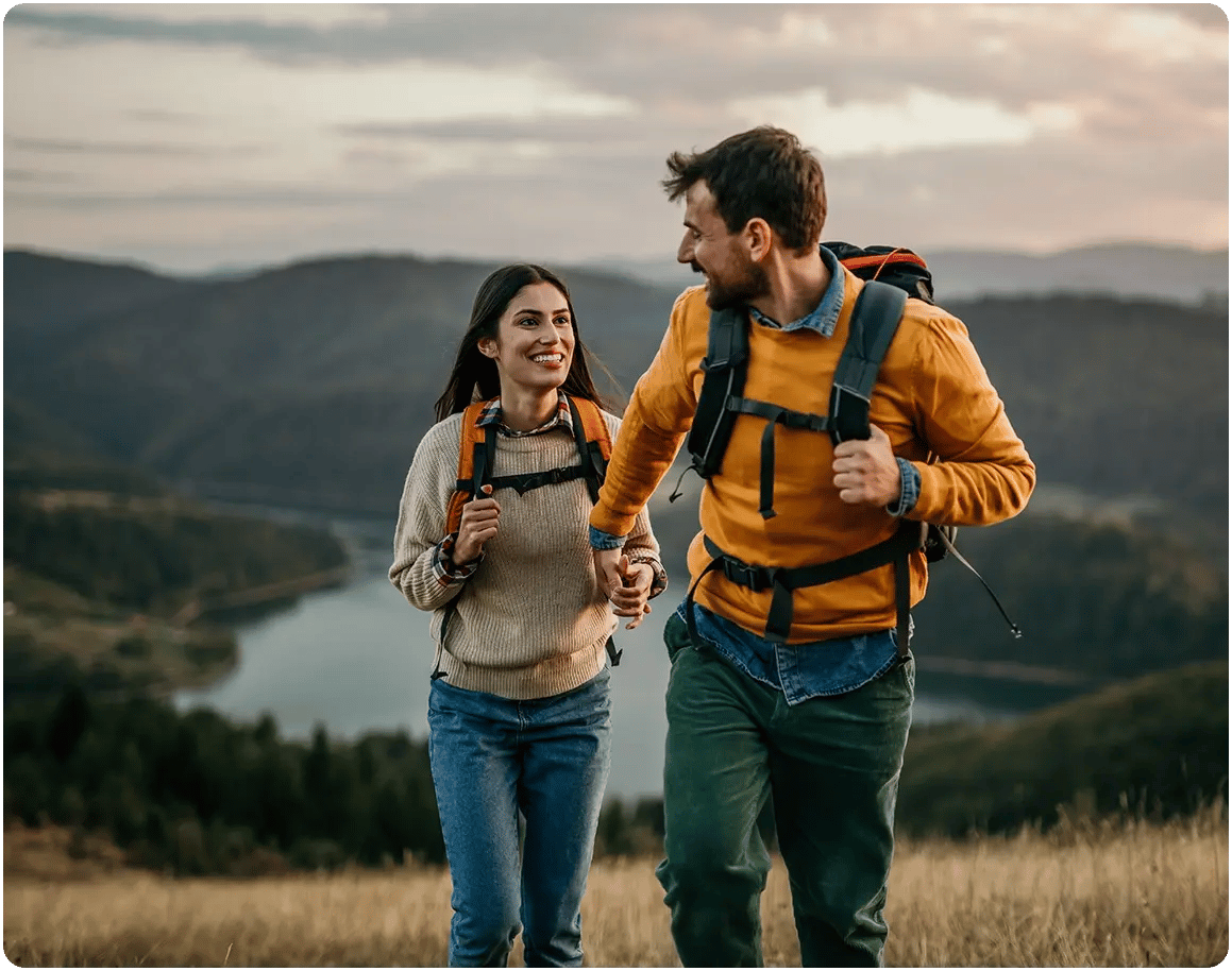 Outdoors couple, hiking through beautiful mountain terrain. 