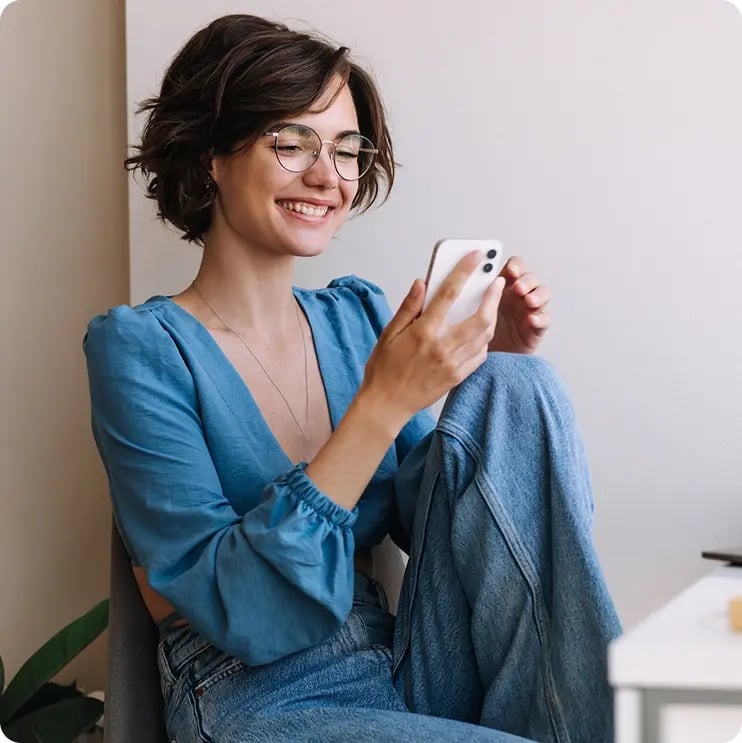 Young adult woman wearing glasses on her phone. 